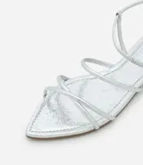 Sandalia plana dorada con tiras finas y cierre con hebilla en el tobillo.