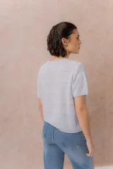 Sweater tejido celeste de manga corta con textura y delicadas líneas horizontales en relieve. Presenta cuello redondo y calce amplio con hombros caídos.