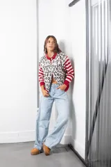 Saco de punto con diseño combinado, presenta un estampado animal print en el cuerpo y mangas con rayas horizontales en rojo y beige. Posee cuello redondo, cierre frontal con botones y terminaciones en tejido acanalado rojo.