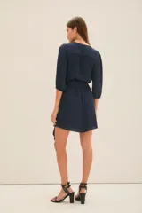 Vestido corto azul marino de manga larga con efecto abullonado en puños, escote cruzado en V y lazo ajustable en la cintura.