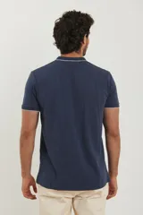 Chomba azul marino de piqué con cuello clásico y tapeta de dos botones. Detalles de ribete blanco en cuello y mangas.