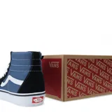 Championes Vans modelo SK8-Hi de caña alta, con diseño en combinación de colores azul marino y negro. Presentan la icónica franja lateral blanca, cordones blancos, puntera reforzada y suela de goma con patrón waffle.