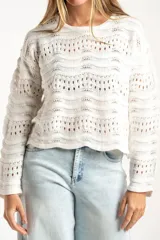 Sweater de punto calado con diseño de ondas horizontales, cuello redondo y mangas largas. Presenta un corte oversize y acabado en color blanco.