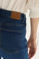 Jean acampanado de tiro alto, color azul medio, confeccionado en denim con un pequeño porcentaje de elastano.