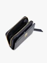 Billetera Tommy Hilfiger azul marino con cierre de cremallera y logo dorado TH en el frente. Cuenta con múltiples ranuras interiores para tarjetas y compartimento para billetes.