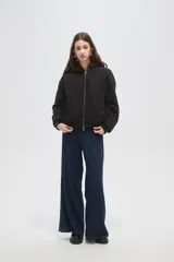 Campera bomber negra con cuello de piel sintética marrón, cierre frontal con cremallera y puños elásticos.