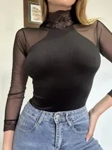 Body negro de terciopelo con mangas largas de tul y detalles de encaje en puños y parte inferior.