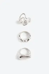 Set de tres anillos de diseño orgánico y voluminoso en color plateado, con formas irregulares y fluidas.