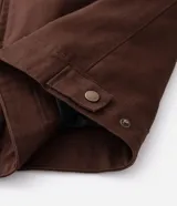 Campera masculina modelo trucker confeccionada en sarga de algodón. Presenta cuello de terciopelo en contraste, cierre frontal con cremallera, manga larga y bolsillo con cremallera en el pecho.