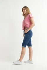 Pantalón capri de denim celeste claro, corte ajustado al cuerpo con tiro alto, bolsillos clásicos y botamangas con vuelta.