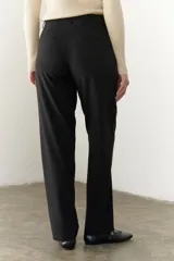 Pantalón negro de corte recto y cintura alta, con bolsillos laterales y cierre.