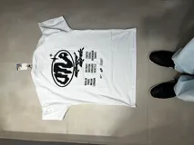 Remera blanca de algodón premium, corte oversize, con estampado en serigrafía en la espalda con logo y listado de ciudades.