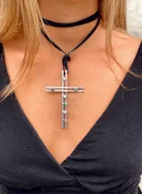 Collar con dije de cruz de alpaca con piedras de circonia de colores. El dije cuelga de un cordón de cuero negro.
