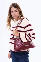 Buzo tejido de punto con diseño a rayas horizontales en color crema y bordó, de cuello redondo y mangas anchas.