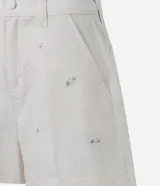 Short de cintura alta confeccionado en tejido de algodón, viscosa y lino. Cuenta con bordado floral, trabillas en la cintura, bolsillos y cierre frontal con botón forrado.