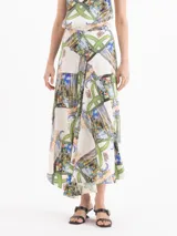 Pollera larga de corte evasé, con fondo blanco y estampado multicolor que incluye elementos de la naturaleza, arquitectura y la inscripción "Ciao Bella".