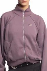 Campera negra de cuello alto con cierre frontal metálico completo, bolsillos laterales y logo bordado en el pecho.