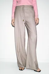 Pantalón de tiro alto con diseño de espiga, pernera recta y bolsillos frontales. Incluye un cinturón trenzado a tono y cierre frontal con cremallera, botón y gancho.