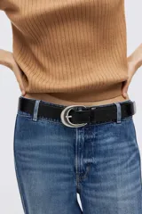 Top corto color tostado en tejido de punto acanalado fino, con cuello tipo polo, tapeta de tres botones y manga tres cuartos. Cuenta con remate acanalado en puños y bajo.