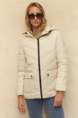 Campera puffer color verde oliva, con capucha, cierre frontal, bolsillos laterales con solapa y elástico en la cintura.