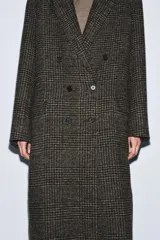 Abrigo largo de Zara Woman Collection, confeccionado en tejido con mezcla de lana. Presenta un diseño de cuadros, cuello con solapas de muesca, cierre frontal cruzado con botones y bolsillos delanteros. Incluye forro interior.