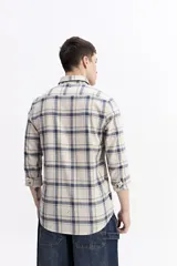 Camisa de manga larga confeccionada en viyela de algodón con diseño de cuadros en tonos azul y verde. Presenta cierre frontal con botones, cuello clásico y bolsillo en el pecho.