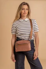 Bandolera de diseño moderno y funcional, confeccionada en nylon color marrón claro. Cuenta con múltiples compartimentos con cierre metálico, herrajes plateados y una correa ancha ajustable con detalle de marca.