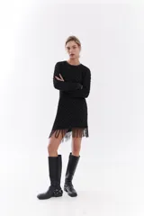 Vestido corto de algodón y lúrex color negro con hilo metálico, manga larga, cuello redondo y detalle de flecos en el ruedo.