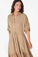 Vestido camisero largo de lino italiano color celeste, de corte relajado, con mangas caídas, jareta ajustable en la cintura, cierre frontal de botones y bajo con volado fruncido.