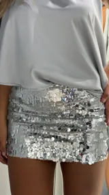 Minifalda de tiro bajo completamente cubierta de lentejuelas plateadas brillantes.