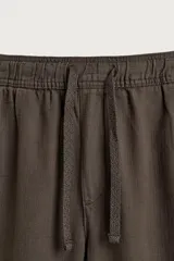 Pantalón de corte regular fit confeccionado en tejido mezcla de algodón, con cintura elástica ajustable mediante cordón, bolsillos laterales y bolsillos traseros de vivo.