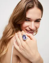 Anillo plateado con cristal rectangular facetado color morado.