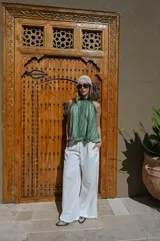 Pantalón de corte amplio y tiro alto, confeccionado en tela negra con acabado brillante y sutil efecto glitter. Presenta cintura elástica con cordón ajustable y caída fluida.