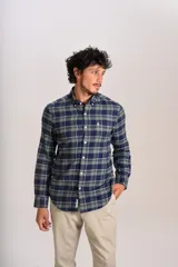 Camisa de manga larga confeccionada en tejido de franela con estampado de cuadros en tonos azul marino y verde. Presenta cuello abotonado, cierre frontal con botones y un bolsillo en el pecho con el logo bordado de la marca.