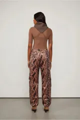 Pantalón cargo de tiro bajo con estampado de piel de serpiente en tonos marrones y negros. Cuenta con puños ajustables y múltiples bolsillos.