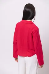 Camisa roja de lino con cuello clásico, mangas largas y cierre frontal con botones.