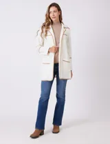 Chaqueta de silueta estructurada y calce recto, confeccionada en tejido jacquard con relieve floral. Presenta cuello con solapas, frente abierto y dos bolsillos de parche frontales. Se destaca por sus vivos a contratono que bordean las solapas, los bolsillos y las costuras horizontales, además de contar con tajos laterales en el ruedo.