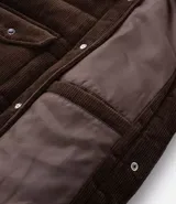 Campera puffer de Marfinno confeccionada en tejido de cotelé de algodón, con diseño acolchado, cuello inglés, cierre frontal con botones y dos bolsillos con solapa en el pecho.