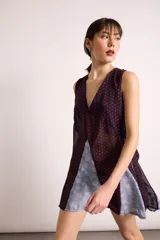 Vestido corto de corte holgado con diseño de doble capa, presentando una capa superior de red y una capa inferior lisa. Posee escote en V profundo, sin mangas y un lazo ajustable en la espalda.