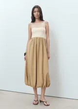 Vestido midi de diseño combinado con cuerpo ajustado en color crema y falda amplia de estilo globo en color tostado. Presenta tirantes finos ajustables, escote recto y bajo abullonado.