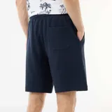 Bermuda azul marino de felpa ligera con cintura elástica ajustable mediante cordón y bolsillos laterales.
