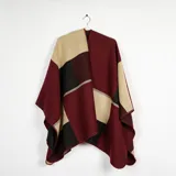 Ruana de tejido de punto con diseño de bloques de color en tonos bordó, beige y negro, con bordes terminados en costura reforzada.