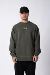 Buzo de cuello redondo con calce oversize, confeccionado en algodón rústico con efecto de lavado gastado. Presenta estampa frontal con el texto 'COFFEE BREAK' y detalle de etiqueta en el puño.