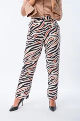 Pantalón largo de poliéster y elastano con estampado abstracto en tonos beige, negro y naranja.