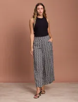 Pantalón fluido de corte recto y largo midi, con estampado abstracto en tonos azul, negro y crema. Presenta cintura elastizada en la parte posterior y bolsillos laterales delanteros.