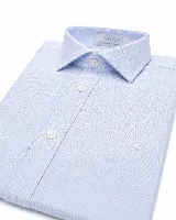 Camisa blanca de manga larga con cuello clásico y cierre frontal de botones, corte semi slim.