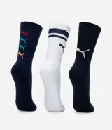 Kit de tres pares de medias deportivas Puma de caña larga. Un par es beige con dos rayas marrones y logo de Puma. Otro par es blanco liso. El tercer par es marrón oscuro con dos rayas blancas y logo de Puma. Todas están confeccionadas en algodón.