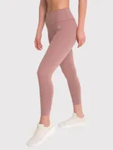 Calza deportiva de tiro alto con largo hasta el tobillo, confeccionada en tejido elástico de color tierra. Presenta un diseño liso sin bolsillos con costuras reforzadas y logo pequeño en la cadera.