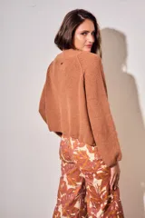 Cardigan oversize de punto color tostado, con cierre frontal y mangas largas.