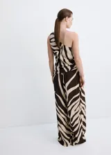 Pantalón largo de tiro medio confeccionado en viscosa fluida, con diseño recto y estampado de cebra en tonos marrón y beige. Cuenta con dos bolsillos laterales y cierre de botón.